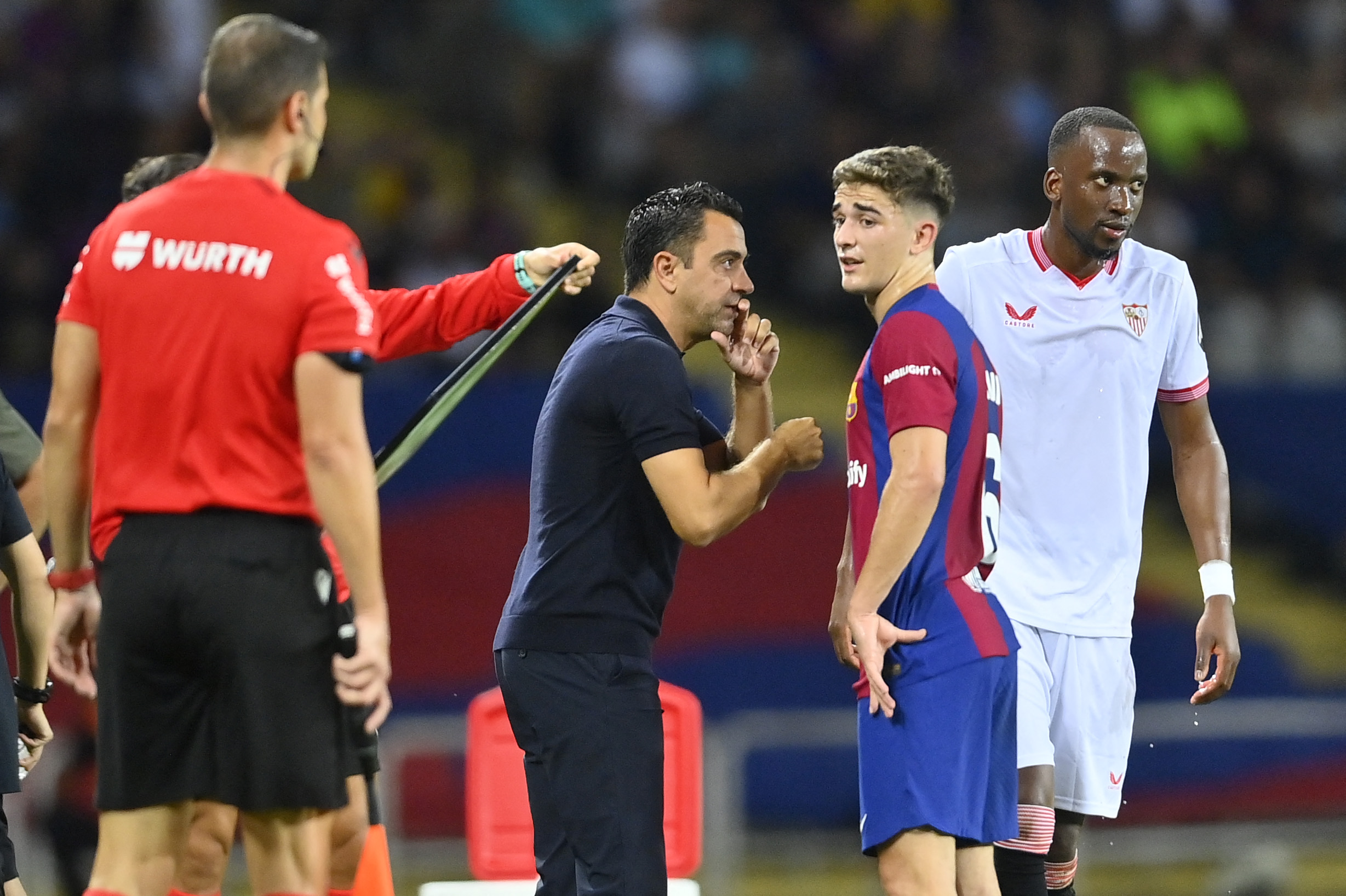 Barcelona's Spanish coach Xavi talks with Barcelona's Spanish midfielder #06 Gavi (2R) as Sevilla's Belgian forward #11 Dodi Lukebakio (R) walks past during the Spanish Liga football match between FC Barcelona and Sevilla FC at the Estadi Olimpic Lluis Companys in Barcelona on September 29, 2023.