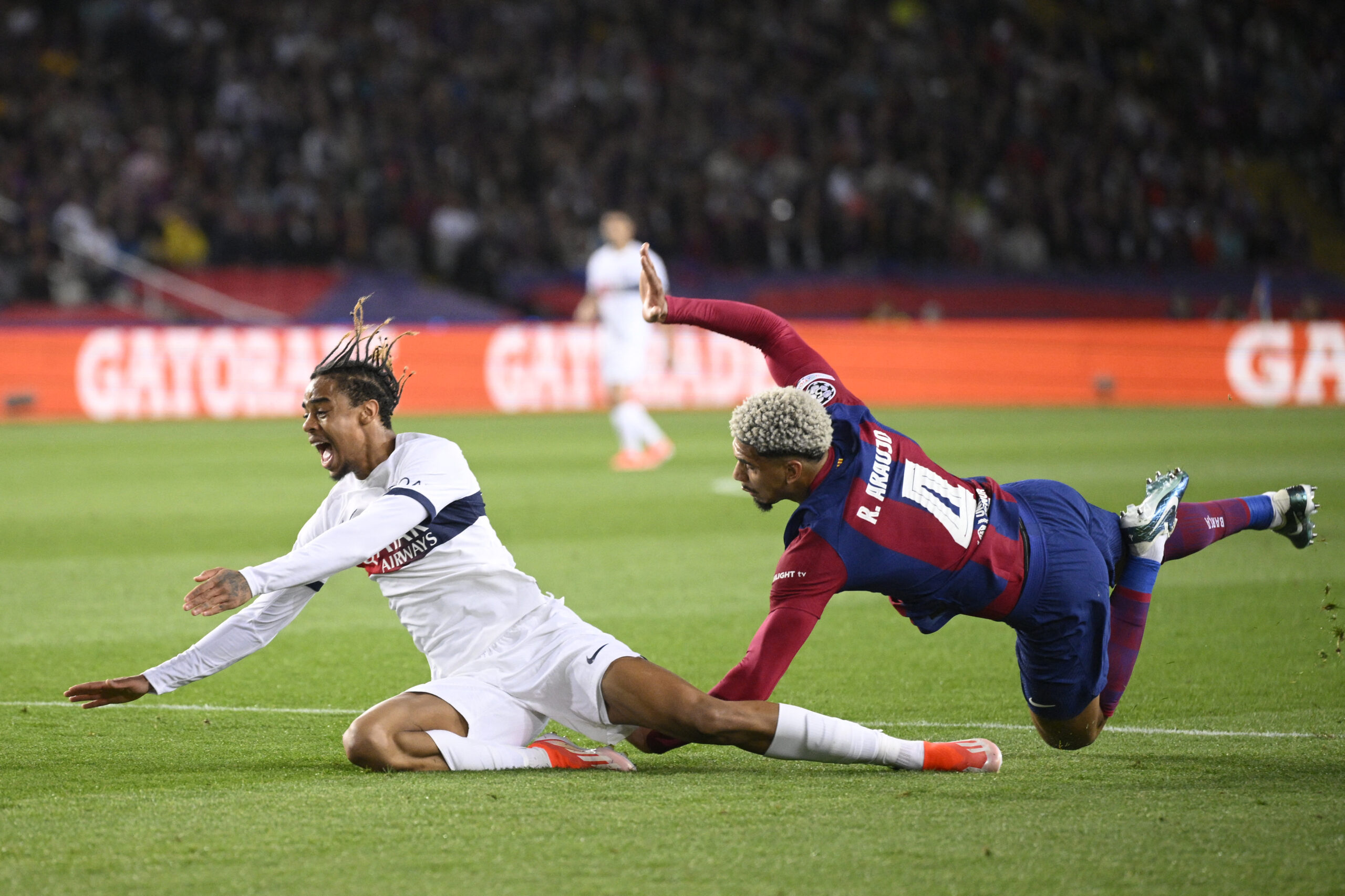 Paris Saint-Germain's French forward #29 Bradley Barcola fights for the ball with Barcelona's Uruguayan defender #04 Ronald Araujo during the UEFA Champions League quarter-final second leg football match between FC Barcelona and Paris SG at the Estadi Olimpic Lluis Companys in Barcelona on April 16, 2024.