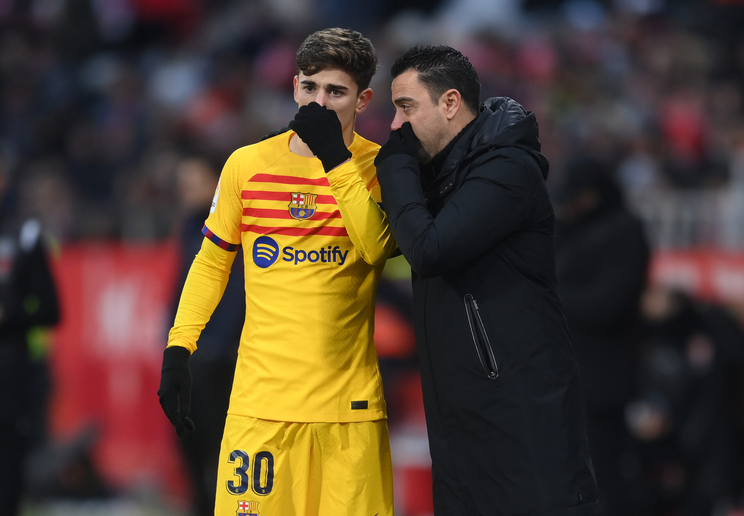 GIRONA, SPAIN - JANUARY 28: Gavi of FC Barcelona speaks with Xavi, Head Coach of FC Barcelona, during the LaLiga Santander match between Girona FC and FC Barcelona at Montilivi Stadium on January 28, 2023 in Girona, Spain.