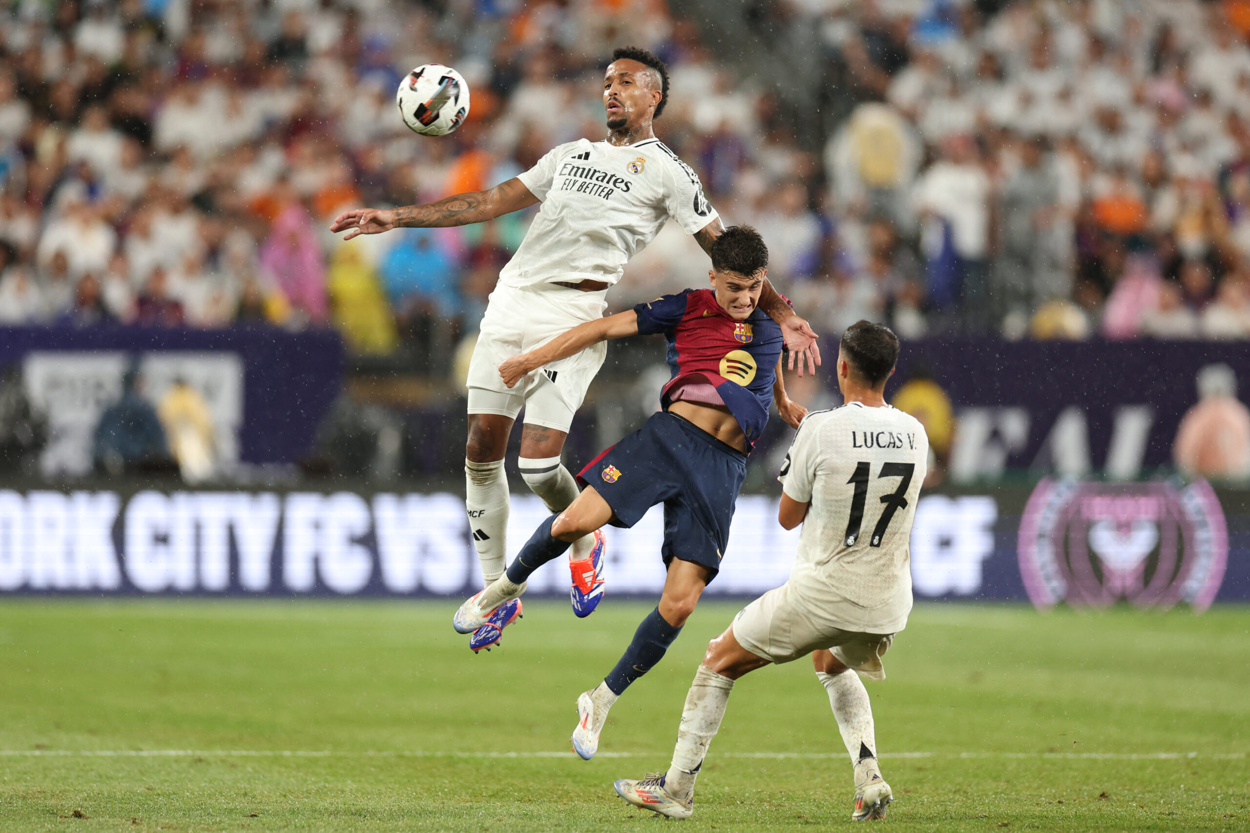 Real Madrid's Brazilian defender #03 Eder Militao (L) vies for the ball with Barcelona's Spanish midfielder #14 Unai Hernandez (C) during the pre-season club friendly football match between Real Madrid and Barcelona at MetLife Stadium in East Rutherford, New Jersey, August 3, 2024.