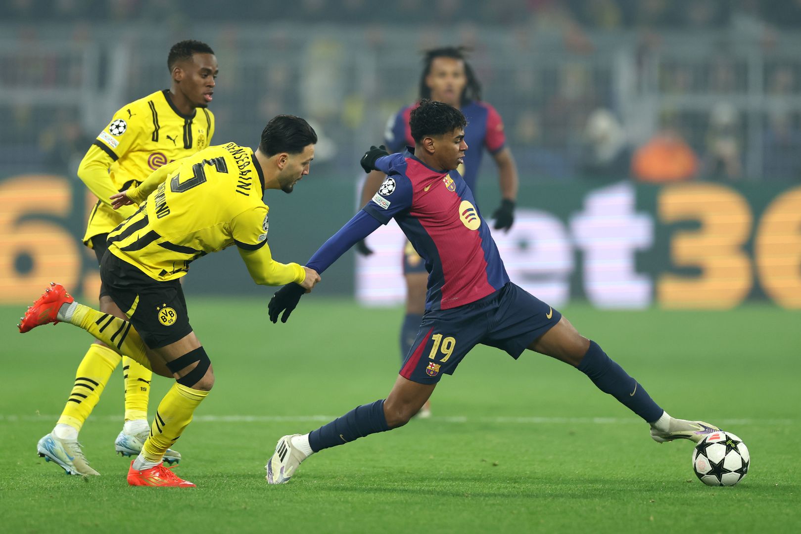 DORTMUND, GERMANY - DECEMBER 11: Lamine Yamal of FC Barcelona controls the ball under pressure from Ramy Bensebaini of Borussia Dortmund during the UEFA Champions League 2024/25 League Phase MD6 match between Borussia Dortmund and FC Barcelona at BVB Stadion Dortmund on December 11, 2024 in Dortmund, Germany.