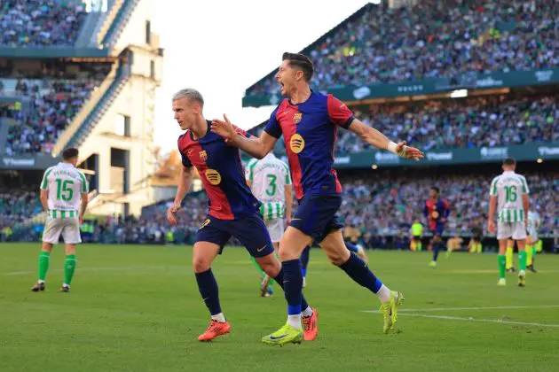 SEVILLE, SPAIN - DECEMBER 07: Robert Lewandowski of FC Barcelona celebrates with teammate Dani Olmo after scoring his team's first goal during the LaLiga match between Real Betis Balompie and FC Barcelona at Estadio Benito Villamarin on December 07, 2024 in Seville, Spain.