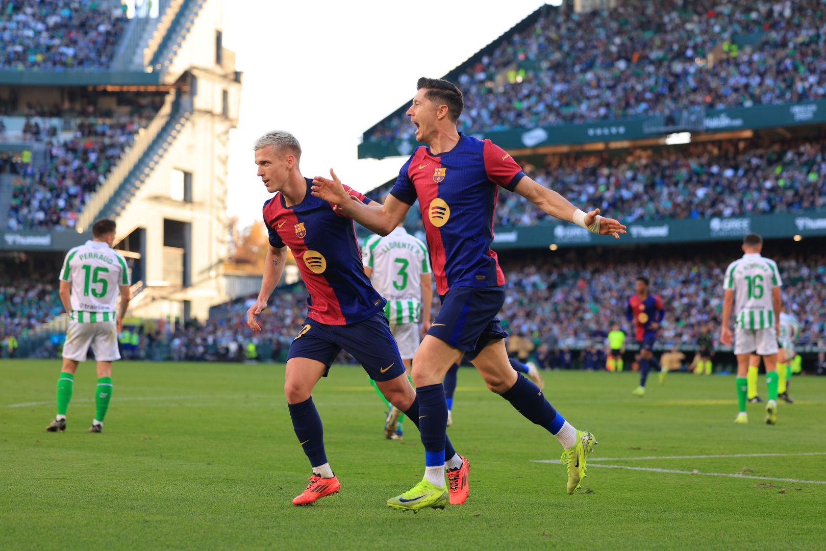 SEVILLE, SPAIN - DECEMBER 07: Robert Lewandowski of FC Barcelona celebrates with teammate Dani Olmo after scoring his team's first goal during the LaLiga match between Real Betis Balompie and FC Barcelona at Estadio Benito Villamarin on December 07, 2024 in Seville, Spain.
