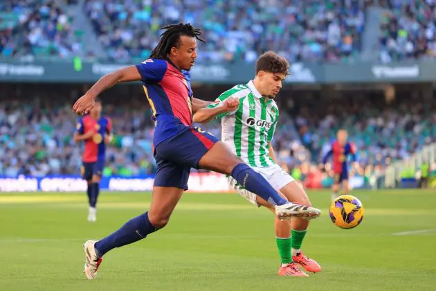 SEVILLE, SPAIN - DECEMBER 07: Jules Kounde of FC Barcelona clears the ball whilst under pressure from Abde Ezzalzouli of Real Betis during the LaLiga match between Real Betis Balompie and FC Barcelona at Estadio Benito Villamarin on December 07, 2024 in Seville, Spain.