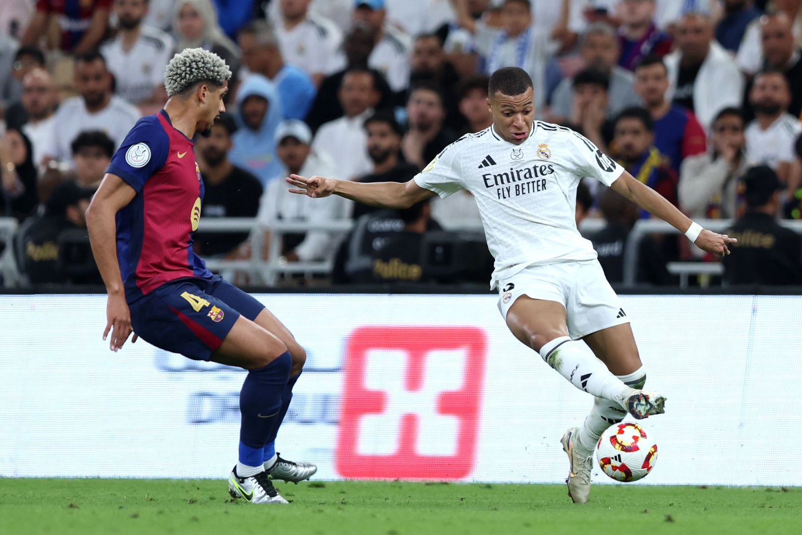JEDDAH, SAUDI ARABIA - JANUARY 12: Kylian Mbappe of Real Madrid runs with the ball whilst under pressure from Ronald Araujo of FC Barcelona during the Spanish Super Cup Final between Real Madrid and FC Barcelona at King Abdullah Sports City on January 12, 2025 in Jeddah, Saudi Arabia.