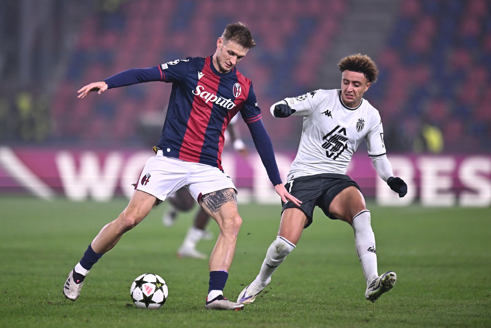 BOLOGNA, ITALY - NOVEMBER 05: Stefan Posch of Bologna controls the ball under pressure from Eliesse Ben Seghir of AS Monaco during the UEFA Champions League 2024/25 League Phase MD4 match between Bologna FC 1909 and AS Monaco at Stadio Renato Dall'Ara on November 05, 2024 in Bologna, Italy.