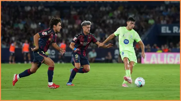 VALENCIA, SPAIN - AUGUST 23: Pedri of FC Barcelona passes the ball whilst under pressure from Ivan Romero of Levante UD during the LaLiga EA Sports match between Levante UD and FC Barcelona at Ciutat de Valencia on August 23, 2025 in Valencia, Spain.