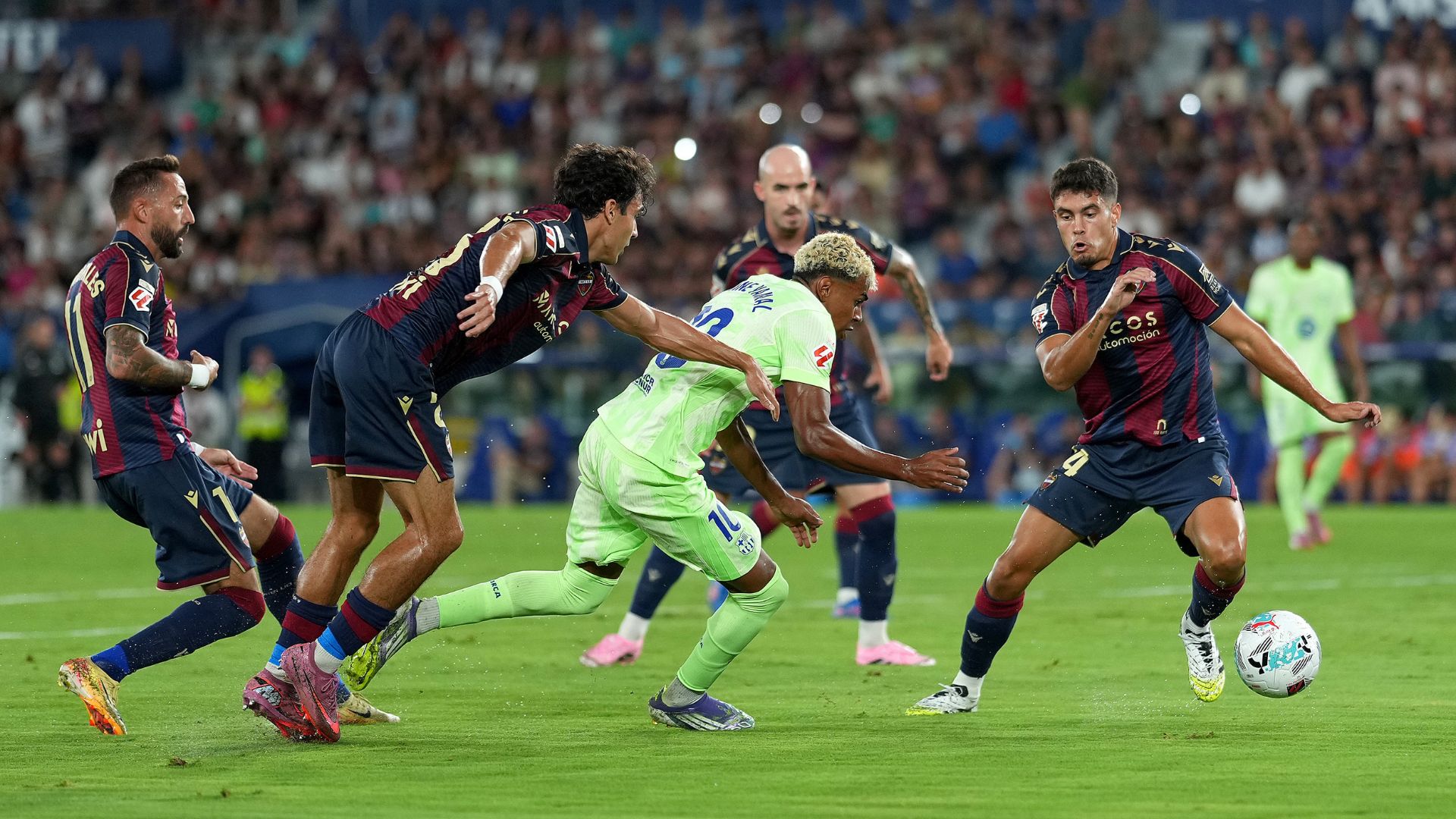 VALENCIA, SPAIN - AUGUST 23: Lamine Yamal of FC Barcelona is challenged by Manuel Sanchez of Levante UD during the LaLiga EA Sports match between Levante UD and FC Barcelona at Ciutat de Valencia on August 23, 2025 in Valencia, Spain.