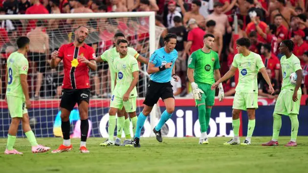 MALLORCA, SPAIN - AUGUST 16: Referee Jose Luis Munuera Montero runs towards the VAR monitor after Vedat Muriqi of RCD Mallorca fouled Joan Garcia of FC Barcelona resulting in a red card being awarded during the LaLiga EA Sports match between RCD Mallorca and FC Barcelona at Estadio de Son Moix on August 16, 2025 in Mallorca, Spain.