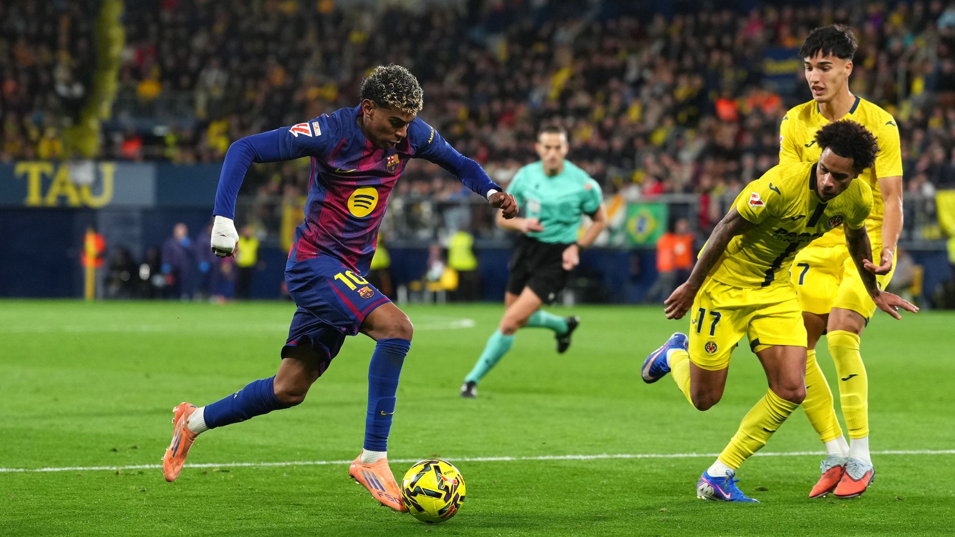 VILLARREAL, SPAIN - DECEMBER 21: Lamine Yamal of FC Barcelona runs with the ball whilst under pressure from Tajon Buchanan of Villarreal CF during the LaLiga EA Sports match between Villarreal CF and FC Barcelona at Estadio de la Ceramica on December 21, 2025 in Villarreal, Spain.
