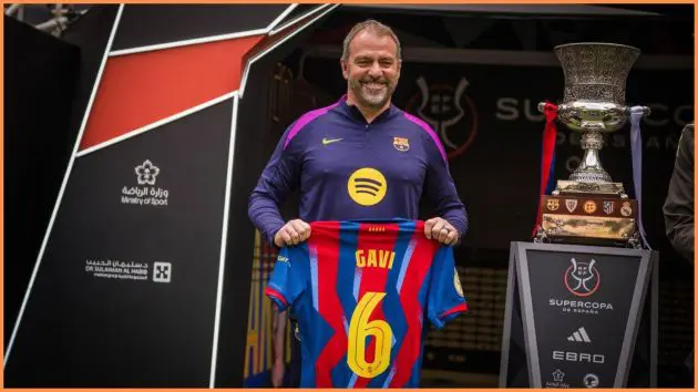 Hansi Flick poses with Gavi's No. 6 Barcelona jersey ahead of the Spanish Super Cup final against Real Madrid.