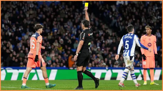 SAN SEBASTIAN, SPAIN - JANUARY 18: Referee Jesus Gil Manzano shows a yellow card to Fermin Lopez of FC Barcelona during the LaLiga EA Sports match between Real Sociedad and FC Barcelona at Estadio Anoeta on January 18, 2026 in San Sebastian, Spain.