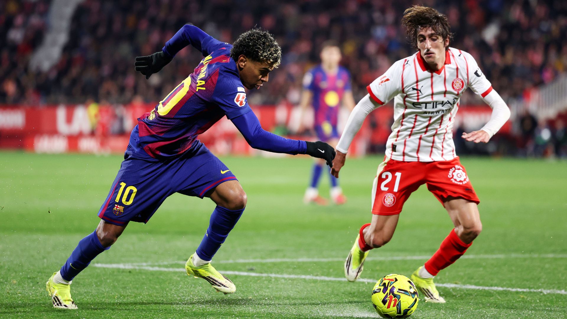 GIRONA, SPAIN - FEBRUARY 16: Lamine Yamal of FC Barcelona runs with the ball whilst under pressure from Bryan Gil of Girona FC during the LaLiga EA Sports match between Girona FC and FC Barcelona at Montilivi Stadium on February 16, 2026 in Girona, Spain.