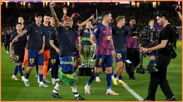 BARCELONA, SPAIN - MAY 10: Raphinha and Robert Lewandowski of FC Barcelona carry the LaLiga EA Sports trophy around the pitch as they celebrate after defeating Real Madrid, and winning the LaLiga title, after the LaLiga EA Sports match between FC Barcelona and Real Madrid CF at Spotify Camp Nou on May 10, 2026 in Barcelona, Spain.