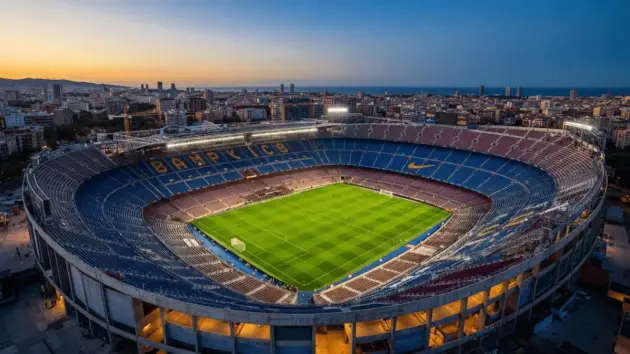 Spotify Camp Nou stadium at dusk with blue and red seats, illuminated pitch, and Barcelona cityscape