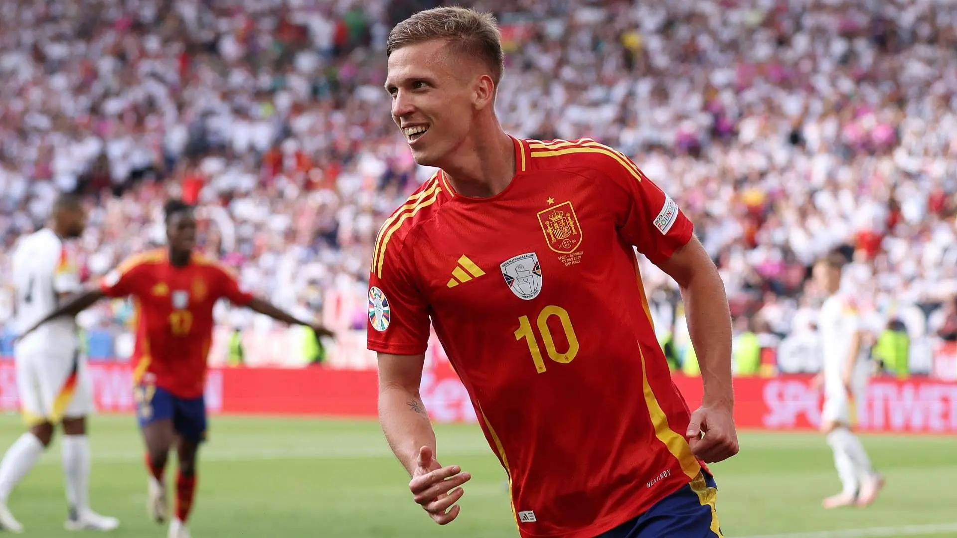 Dani Olmo celebrating a goal while wearing Spain's national team jersey.