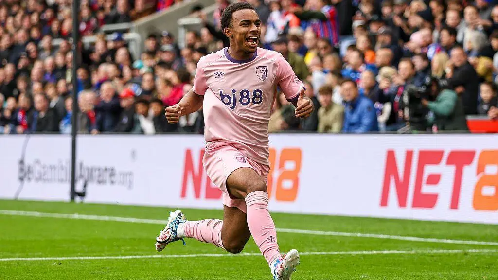 Eli Junior Kroupi celebrating in a pink Bournemouth kit during a football match