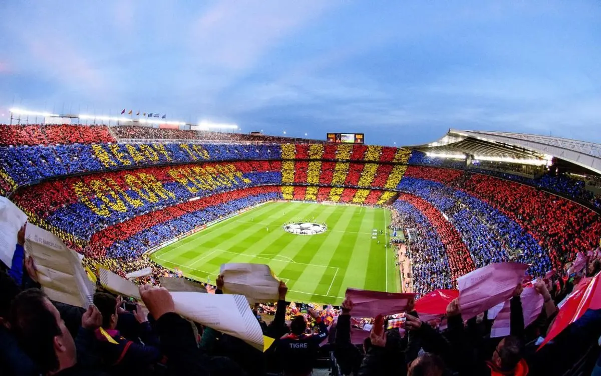 Camp Nou stadium filled with fans holding colored cards in FC Barcelona colors.