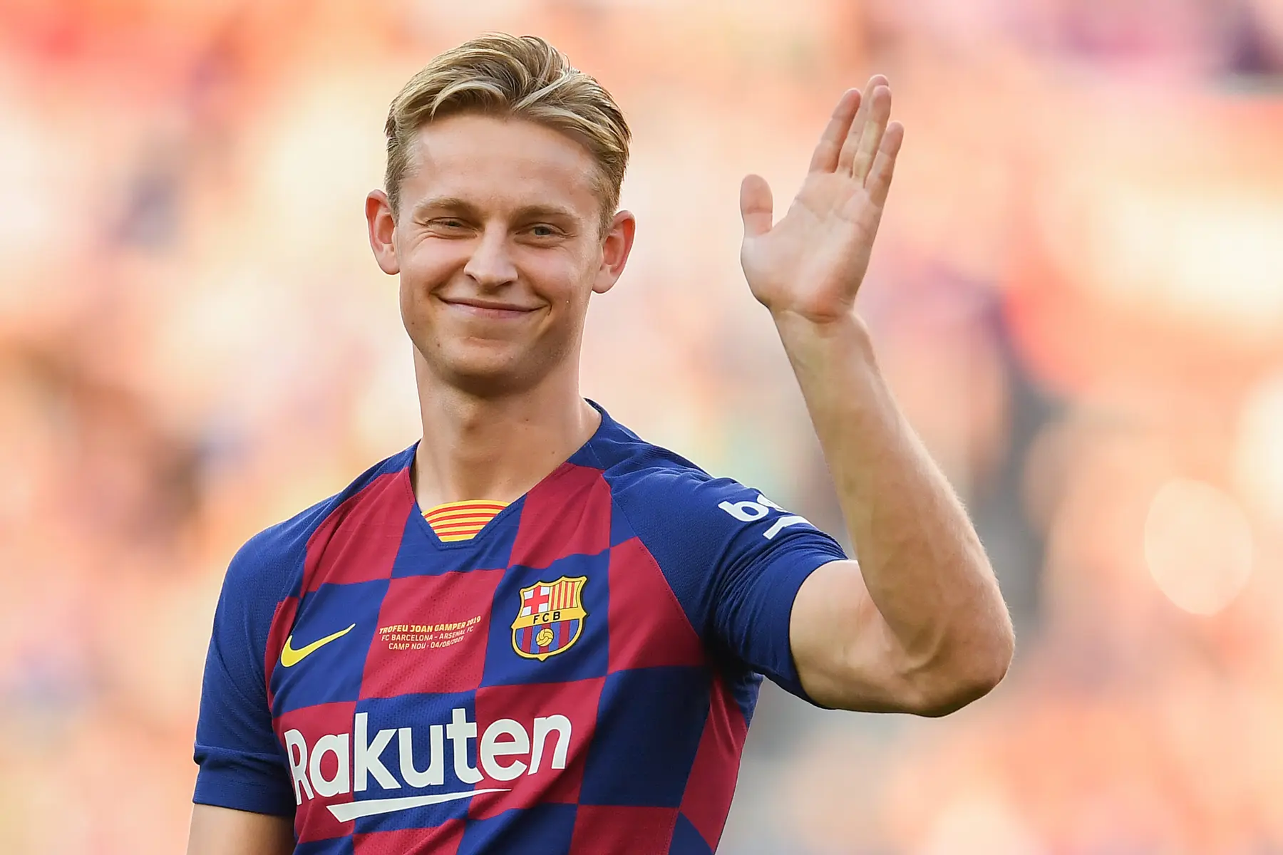 Frenkie de Jong waving during a Barcelona match, wearing the team's colors.