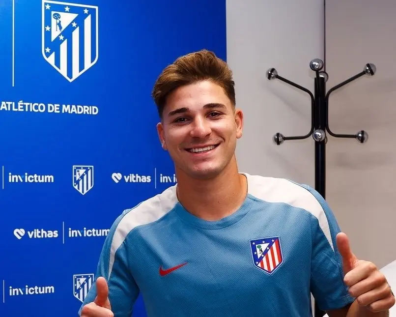 Julian Alvarez smiling and wearing a light blue Atletico Madrid training jersey