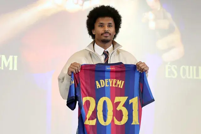Karim Adeyemi holding a FC Barcelona jersey with his name and the number 2031.