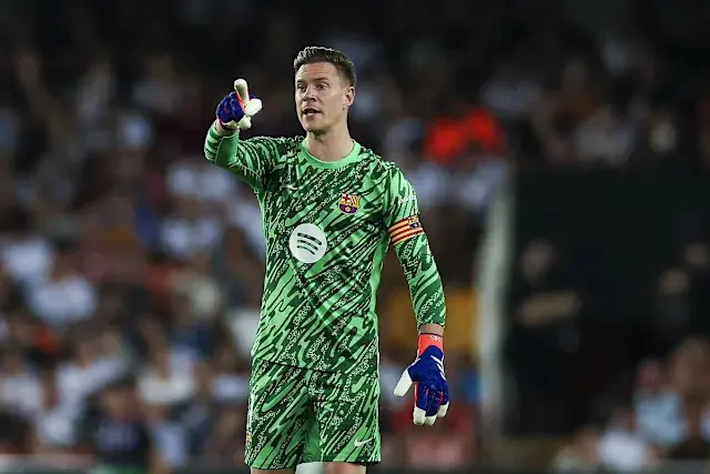 Marc-André ter Stegen in a green patterned FC Barcelona goalkeeper kit, gesturing with one gloved hand.