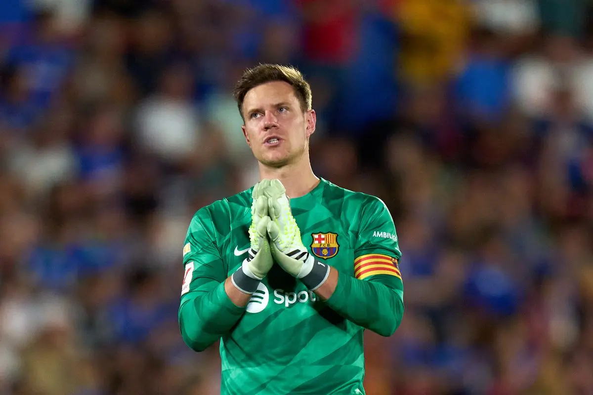 Marc-André ter Stegen in a green FC Barcelona goalkeeper jersey clapping his hands on the pitch.