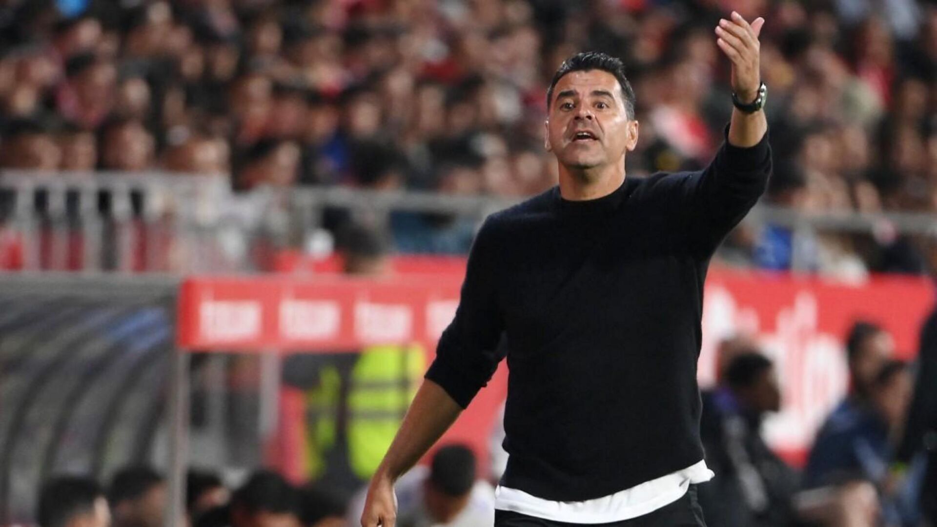 Michel Sanchez coaching on the sidelines during a football match.