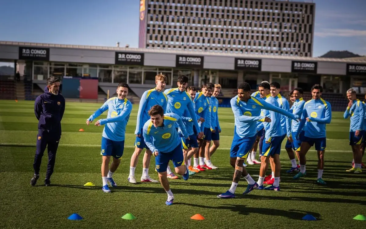 FC Barcelona players, including Gavi, training on a grass pitch in light blue training gear