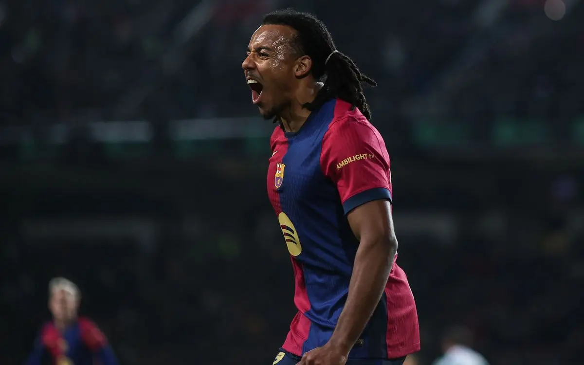 Jules Koundé shouting in celebration while wearing an FC Barcelona home jersey during a match.
