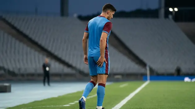 Anonymous football winger holding his right thigh during a precautionary injury assessment