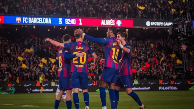FC Barcelona players celebrating a goal, including Raphinha wearing jersey number 11.