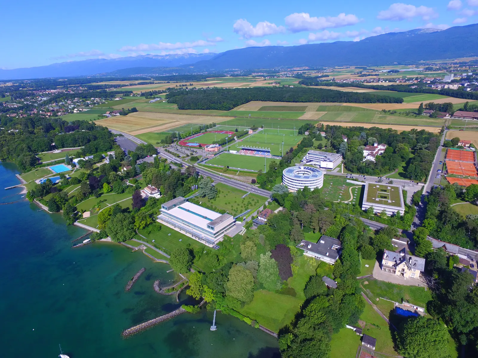 Aerial view of the UEFA headquarters complex and surrounding landscape by a lake.